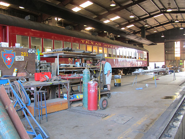 A large passenger car is currently in the workshop for restoration.