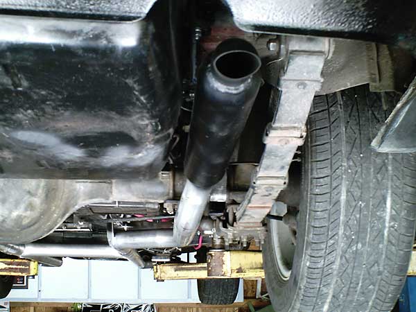 Glass-pack mufflers on either side of a centered fuel tank