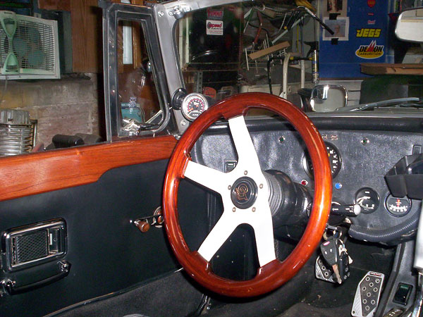 Grant wood rimmed steering wheel. Custom wooden door caps and window crank handles.