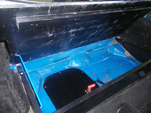 The front section of the cargo shelf lifts up for battery and cut-off switch access.