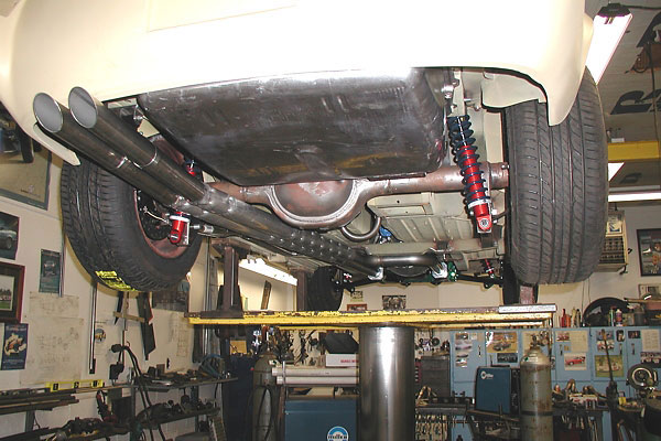 The tailpipes are routed straight across under the rear axle.