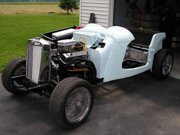 Installing the MG TD's body onto its chassis.