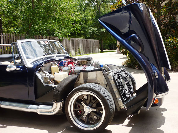 Chevrolet 383cid V8 with custom 4-into-1 headers and modified Cobra sidepipes.