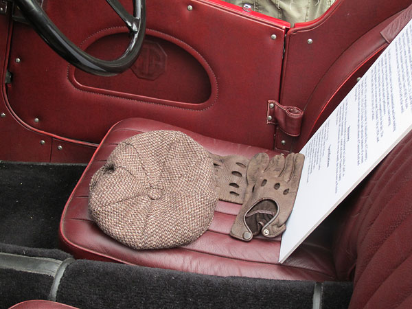 Tweed cap and leather driving gloves.