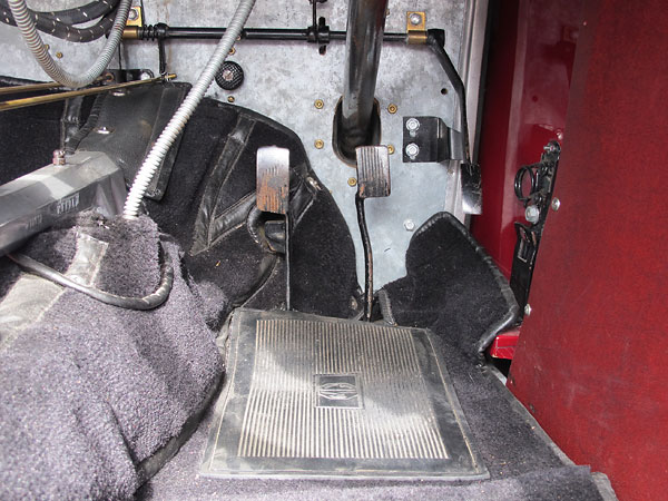 The round device above and to the left of the clutch pedal is the engine's starter switch.