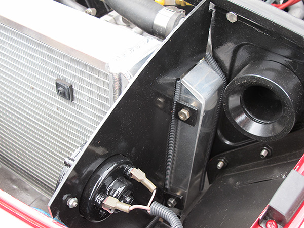Electric horn mounted on radiator baffle.