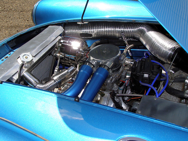 The carburetor is now connected to the air cleaner by rigid metal tubing, painted body-color.