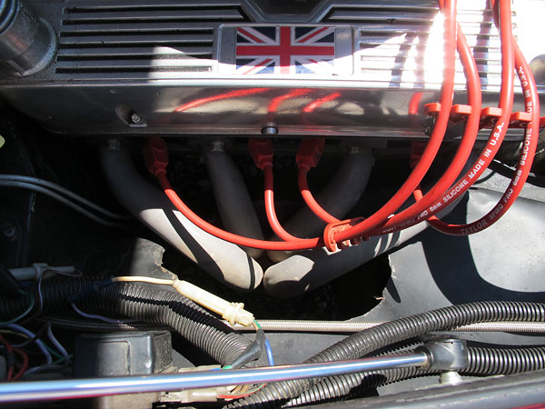 MG RV8-style through-the-wing four into one exhaust headers.