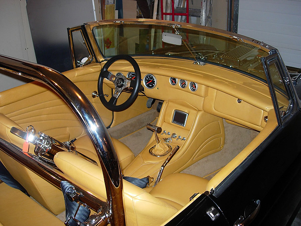 Owner built custom dash, center console, and door panels, all covered in tan leather.