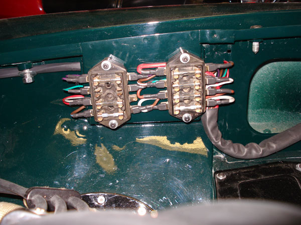 Custom wiring with eight fuses where once there were four. (Note also heat shrink tubing.)