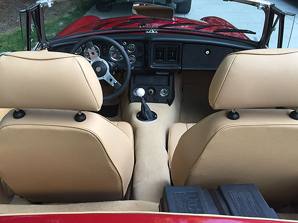 12V battery inside a marine battery box, mounted behind the passenger seat.