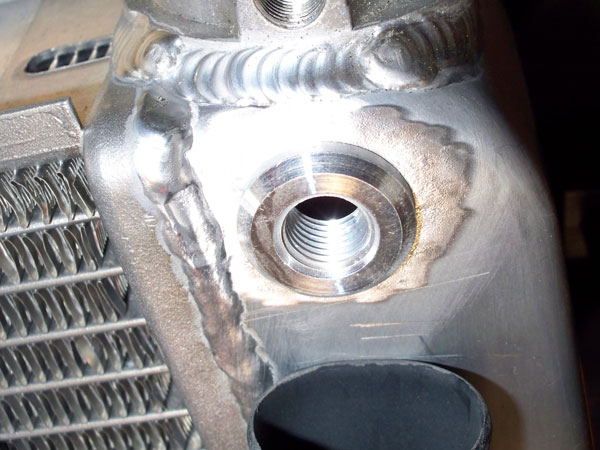 1/4 inch NPT threaded aluminum bung installed on the radiator to vent out trapped air.